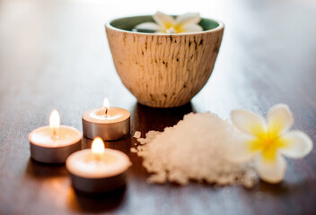 Wellness, spa candles or salt with flowers on table for aromatherapy treatment, self care retreat or tranquil setup. Interior space, health clinic or empty room with organic product for stress relief