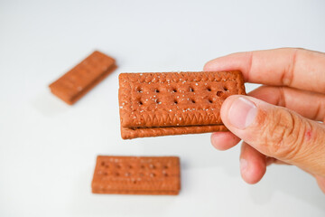 Crispy Chocolate Layered Biscuits Being Held in Hands on a White Background