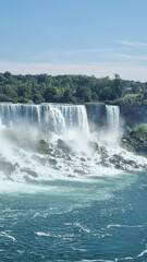Obraz premium Niagara Falls. A pleasure boat with people near the huge famous waterfall. View from the Canadian side. Nature scenery. Photo for advertising