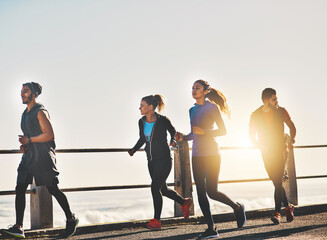 Friends, fitness and running with sunset by beach for cardio workout, exercise or training together...