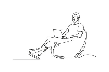 Relaxed Man Working from Home on Laptop in Beanbag Chair