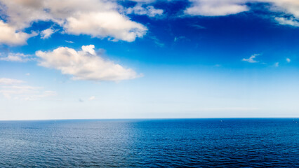 Obraz premium panoramic drone view of clouds in blue sky over ocean