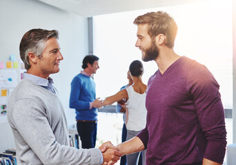 Obraz premium Businessmen, meeting or handshake with team for collaboration, agreement or partnership at office. Male people, colleagues or creative designers shaking hands with smile for project idea at workplace