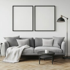 A modern living room featuring a gray couch with decorative pillows, a cozy throw, a round coffee table, and two empty frames on the wall.