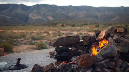 Mountain, camping and pot of food on fire, charcoal and rocks for grill, bbq and cooking outdoors in nature. Travel, barbecue and meal for nutrition for journey, adventure and survival at campfire