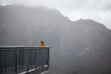 woman orange jacket hat lookout mist winter cold fog