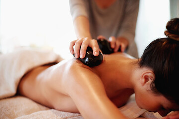 Hands, resort and hot stone massage for back, muscle recovery and stress relief on holiday at spa....