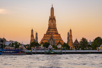 Fototapeta premium Majestic sunset over Wat Arun in Bangkok Thailand illuminating the Chao Phraya River