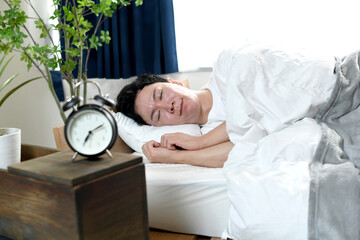 寝室で良質な睡眠・熟睡・快眠をする男性