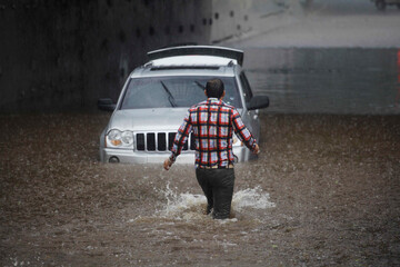 Fototapeta na wymiar Driver gets stuck with his car in Marginal avenue during a big flood amid heavy rains in Sao Paulo, Brazil.