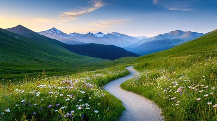 A winding trail cutting through a mountain range, surrounded by wildflowers in full bloom