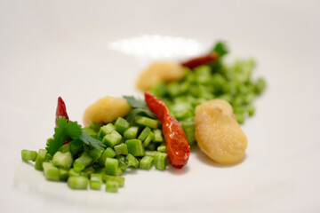 Refined Mexican cactus salad with cilantro, beans, and red peppers elegantly presented.