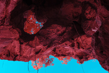 Infrared techniques, a stunning view from within a cave, looking up towards the sky. The cave...