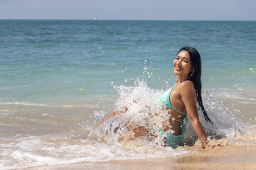Fototapeta premium Sea waves crashing against a woman in a bikini