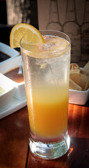 Refreshing layered orange juice and sparkling water served in a tall glass, garnished with a slice of orange.