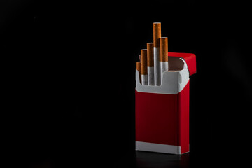Open red pack of cigarettes on black background