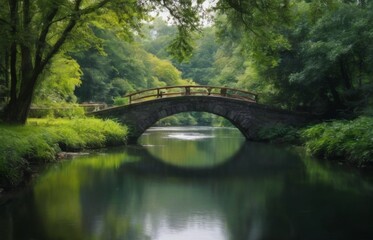 Fototapeta premium Serene stone bridge over calm river, with lush greenery reflecting in still water, under peaceful overcast sky.
