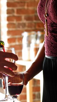 Mid section of couple having red wine