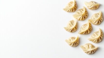 Fototapeta premium A close-up of neatly arranged dumplings on a white background, showcasing their intricate folds and shapes.