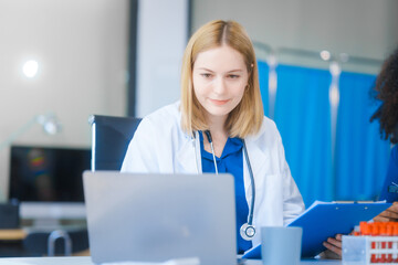 Young African American and Russian woman, both scientists, collaborate to analyze blood samples,...