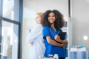 Fototapeta premium Young African American and Russian woman, both scientists, collaborate to analyze blood samples, viruses, vaccines using microscopes. They conduct crucial medical and biological research.