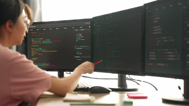 Slow motion back end software developer engineer for computer programming working together on debugging writing computing code, solving complex algorithms display on monitor in office. Burgeoning
