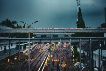 Urban Train Station Viewed from Bridge with Tracks and Commuters