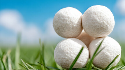 White balls stacked on grass, blue sky background; nature product