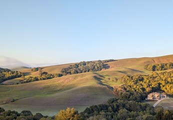 morning sun glows warmly over lush, rolling hills