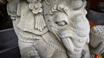 Garden Gnome traditional stone statue situated in a tranquil tropical garden, surrounded by vibrant foliage and artistic decor, harmonizing with the natural beauty of its environment