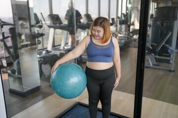 Sporty woman exercising on ball fitness workout and health concept. training working out and sitting on gymnastic fitball at gym