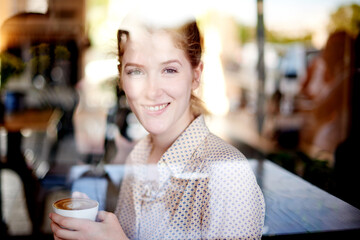 Happy woman, portrait or customer with coffee by window for morning beverage, drink or relax at indoor restaurant. Female person, face or smile with mug for caffeine, cappuccino or latte at cafe