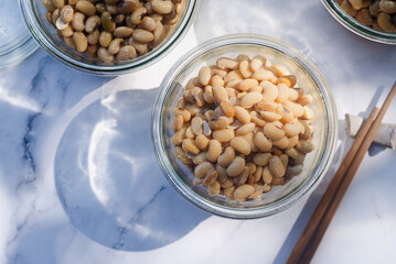 homemade natto fermented soy bean in a glass bowl on marble background.