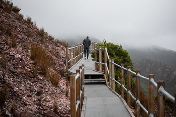 man behind walking path hike mountains cold winter jacket