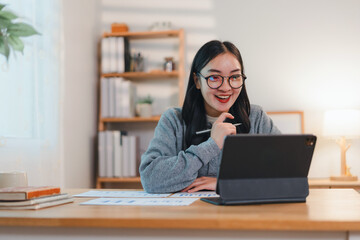 Fototapeta premium cheerful woman working on tablet at desk in bright home office environment