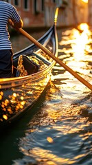 Obraz premium Gondolier Rowing Gondola at Sunset on Venetian Canal