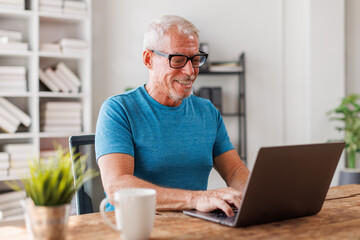 Fototapeta premium Senior, man and happy with portrait, Businessman using laptop computer in office. Happy middle aged man, entrepreneur, small business owner working online.