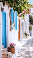 Naklejka premium Vibrant flowers and a bright blue door adorn a charming whitewashed alley.