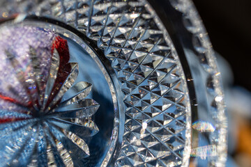 Defocused macro abstract texture background view of a beautiful lead crystal goblet surface with sunburst and diamond facet cuts