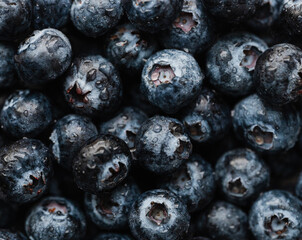 Close up of fresh blueberries covered in water droplets from above.