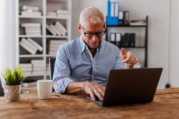 Fototapeta premium Portrait of around the age of 55s,Happy handsome Senior, man or businessman looking at webcam making conference video call