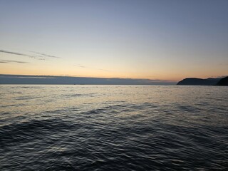 Obraz premium Colorful ocean beach sunrise with deep blue sky and sun.