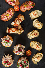 Colorful toppings and spreads are beautifully presented on toasted bread and slate, inviting anyone to indulge in a delicious culinary experience filled with textures and flavors. 