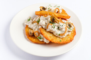 Delight in a mouthwatering stack of crispy potato pancakes, generously layered with rich mushroom sauce, garnished with fried onions and fresh herbs. Perfect for a comforting meal. 
