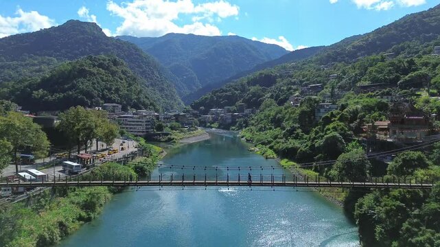 Aerial 4K footage of a pedestrian bridge on top of a river in New Taipei City, Taiwan. 