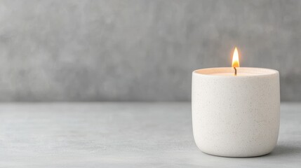 Lit candle on grey surface, tranquil background. Relaxation, spa, home decor