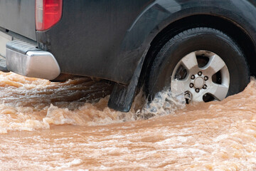 Muddy rain from a heavy rainy season flooded main roads connecting the district, making it difficult for cars to pass through and causing engine failures, in motion, car insurance concept, in motion.