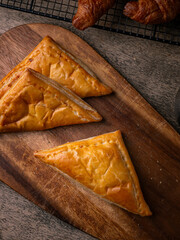 Fresh Baked puff pastry pie with filling on wooden cafe table