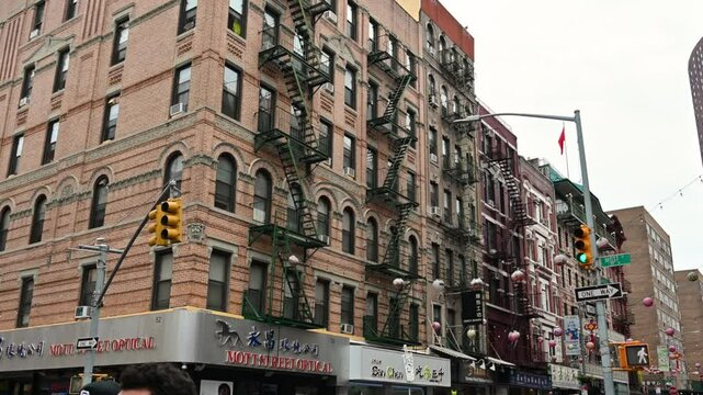 New York, USA, August 17, 2024. Static footage in the heart of the Chinatown neighborhood. Colorful paper lanterns and Chinese signs, fire escapes on brick-faced buildings.