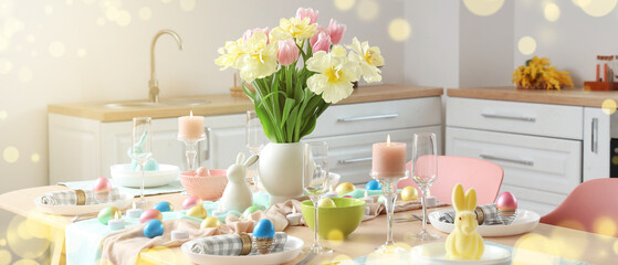 Modern interior of stylish kitchen with Easter table setting, counters and vase of flowers